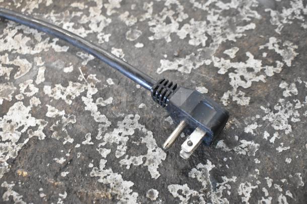 Power cord for Maxx Cold MXCR48MHC Sandwich Salad Prep Table, 115V, 1 Phase, visible on rough surface.