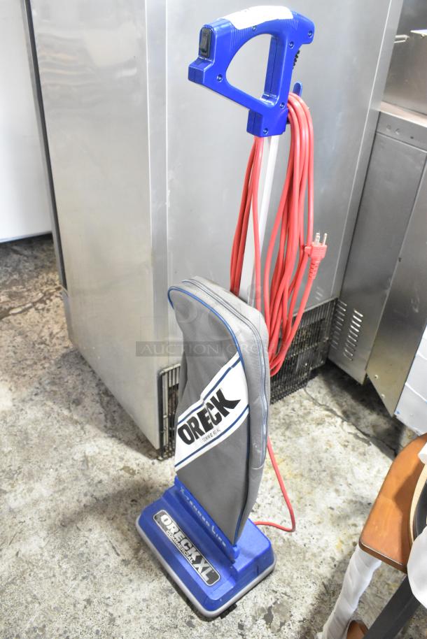 Brand new Oreck XL2100RHS 12" lightweight upright bagged vacuum cleaner. Scratch and dent; 120 volts, 1 phase.