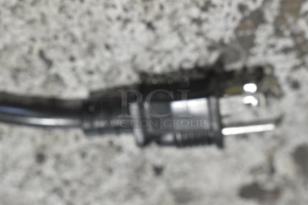 Blurry image of a power plug on a textured surface, unrelated to Avantco 177W50CKR stainless steel countertop food warmer.