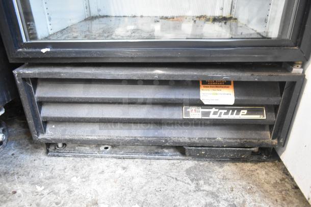 True GDM-12 cooler with glass door, worn exterior, True logo, and warranty tag. Poly coated racks and 115V, 1 phase.
