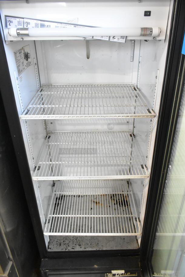 True GDM-12 single door cooler with poly-coated racks, 115 volts, 1 phase. Visible wear on racks and interior base.