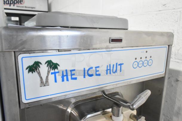 Taylor 441-33 stainless steel commercial soft serve ice cream machine on casters. Label reads "The Ice Hut."