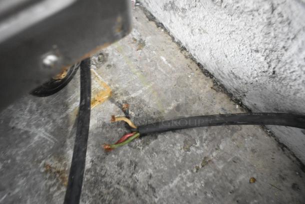 Damaged power cord of Taylor 441-33 soft serve ice cream machine on floor. Worn and frayed ends visible.