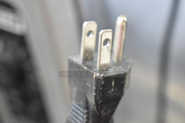 Close-up of a three-prong electrical plug from a Great Northern 6128 popcorn machine, indicating a 120-volt connection.