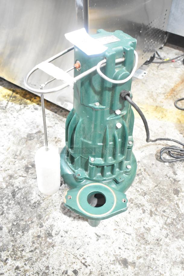 Zoeller M2B2-D metal pump, 115 volts, 1 phase. Green casing, visible wiring, used condition, model plate on top.