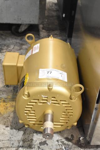 Baldor SuperE motor, like new, 230/460 volts, 3 phase. Gold casing with labels, model information, and auction tag visible.