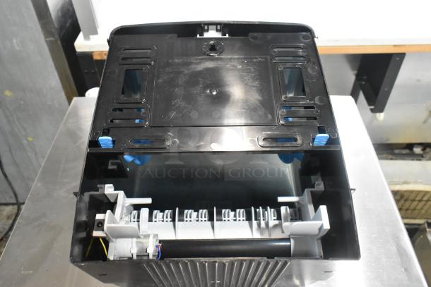 Lavex Select black poly wall mount paper towel dispenser, sturdy build, open view showing internal mechanisms, slight wear visible.