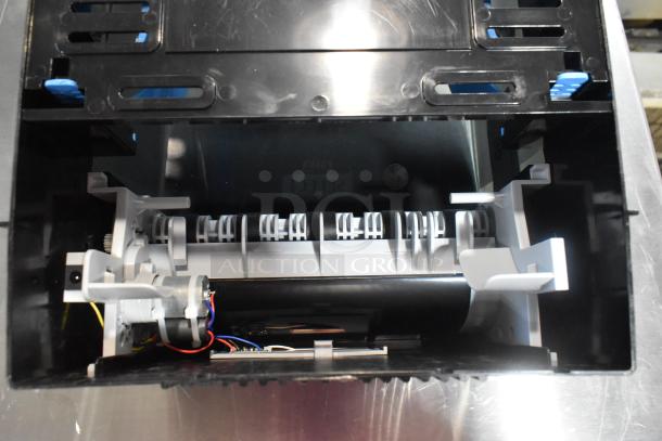 Lavex Select black poly wall mount paper towel dispenser, internal view showing mechanism, in unused condition.
