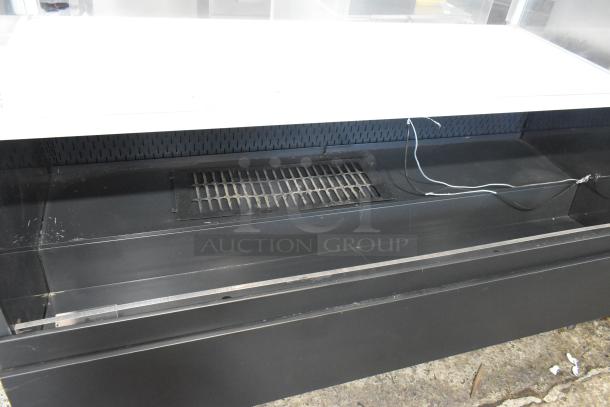 Metal commercial horizontal open merchandiser with top display case, black finish, visible wiring, moderate wear.