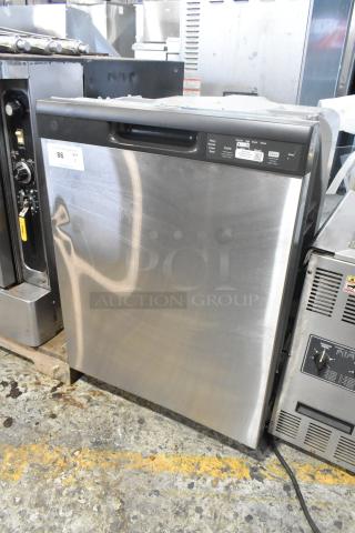 Stainless steel undercounter dishwasher with control panel. Visible wear on the surface. Auction tag marked "86 QTY 1."