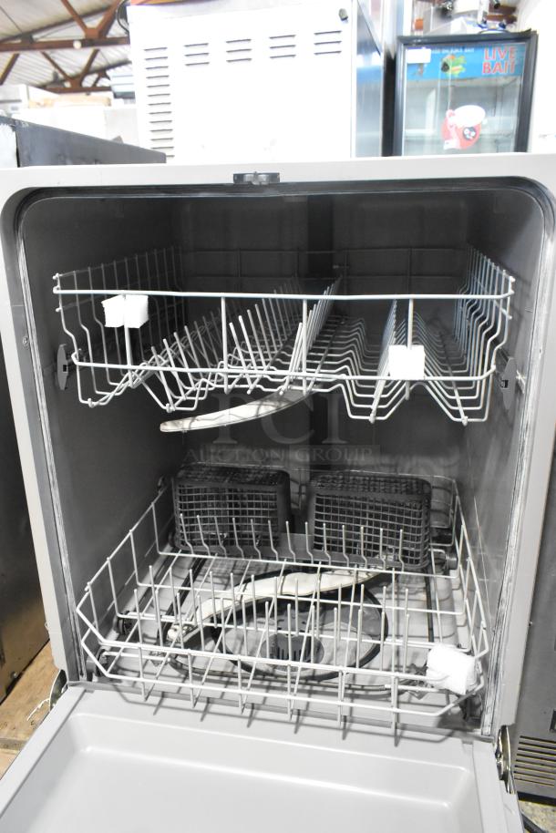 Stainless steel undercounter dishwasher, open view showing interior racks and components, in good condition.