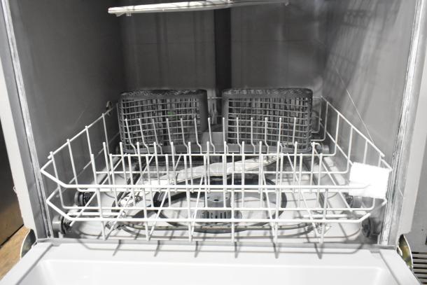 Stainless steel undercounter dishwasher with spacious interior, two racks, and silverware basket. Excellent condition.