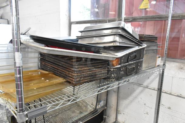 Auction lot of metal baking pans, stainless steel drop-in bins, and poly drop-in bin lids on a metal shelf. Signs of wear visible.