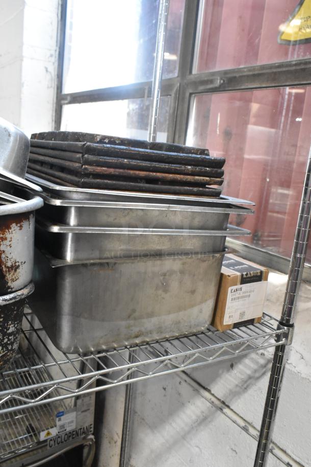 Tier lot with metal baking pans, stainless steel drop-in bins, and poly bin lids. Various conditions. Visible labels on a box.