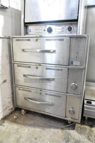 Wells RW-3 stainless steel commercial warming drawer, 3-drawer model on casters, 120V, 1 phase. Some visible wear.