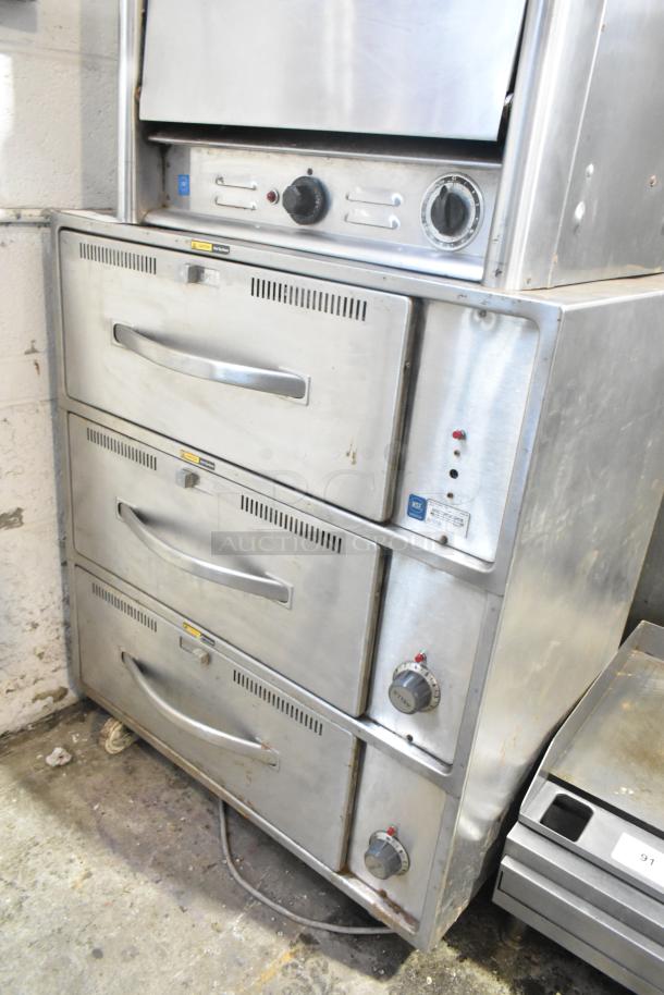 Wells RW-3 stainless steel 3-drawer warming drawer on commercial casters, 120V, 1 phase; handles and controls visible.