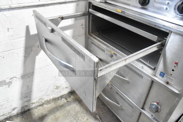 Wells RW-3 stainless steel 3-drawer warming unit on casters, 120V, good condition, visible NSF certification label.