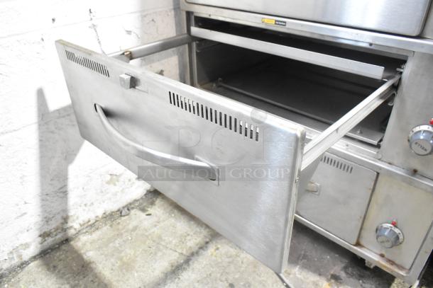 Wells RW-3 stainless steel 3-drawer warming drawer on commercial casters, 120V, 1 phase, shown open with visible handle and controls.