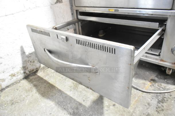 Wells RW-3 stainless steel commercial warming drawer, 3-drawer unit, on casters, 120 volts, some surface wear visible.