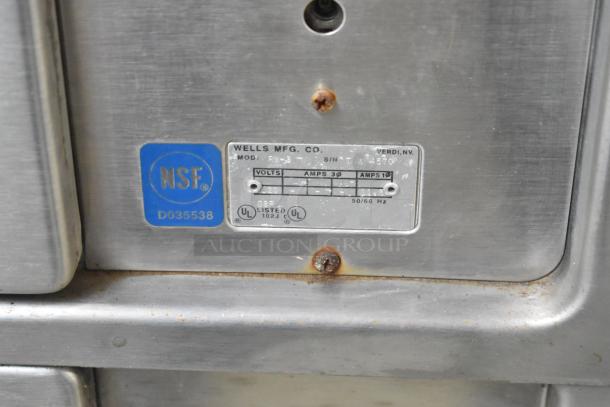 Wells RW-3 stainless steel 3-drawer warming drawer on commercial casters with NSF label and model plate showing 120 volts, 1 phase.