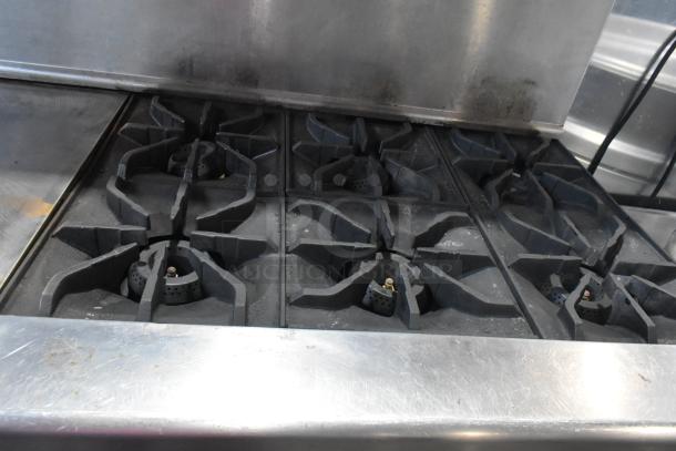 Imperial stainless steel commercial gas range with 6 burners, flat top griddle, convection and standard oven, over shelf, and backsplash.
