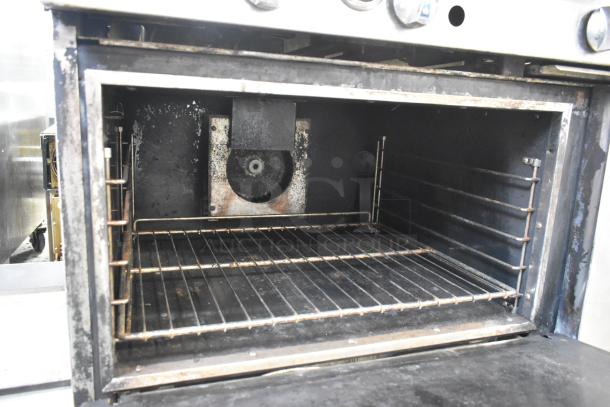 Imperial commercial gas-powered convection oven interior. Features include racks and visible wear consistent with use.