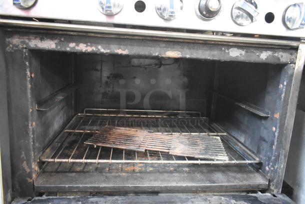 Imperial commercial gas range with 6 burners, flat top griddle, convection oven, standard oven, overhead shelf, and backsplash.