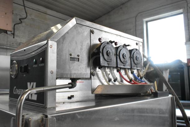 Jackson Conserver XL Stainless Steel Commercial Dishwasher, 115V, 1 Phase. Features control panel, hoses, and visible wear.