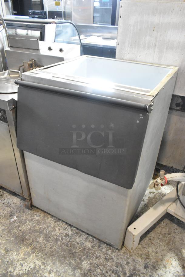 Stainless steel commercial ice bin with black lid, in used condition. Ideal for restaurant or bar use. No visible markings.