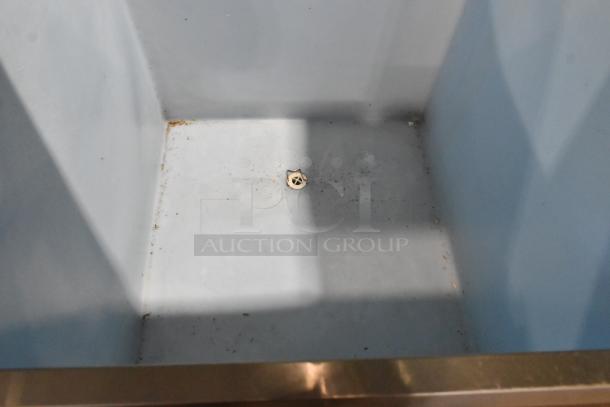 Stainless Steel Commercial Ice Bin with visible interior drainage. Used condition with some residue and wear at edges.