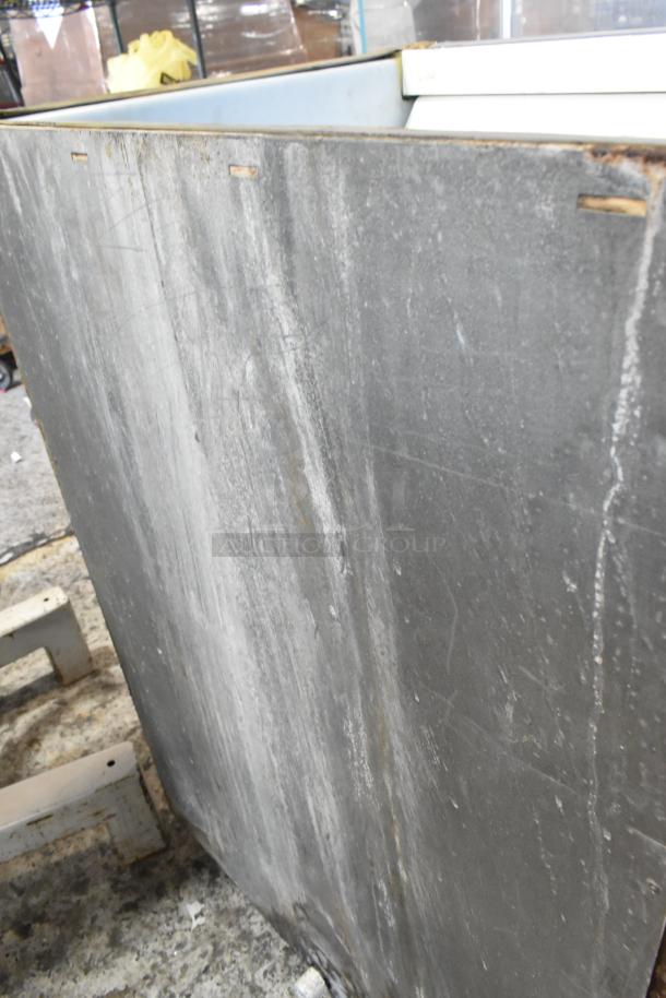 Stainless steel commercial ice bin with visible wear. Ideal for restaurants. Durable construction, needs cleaning.