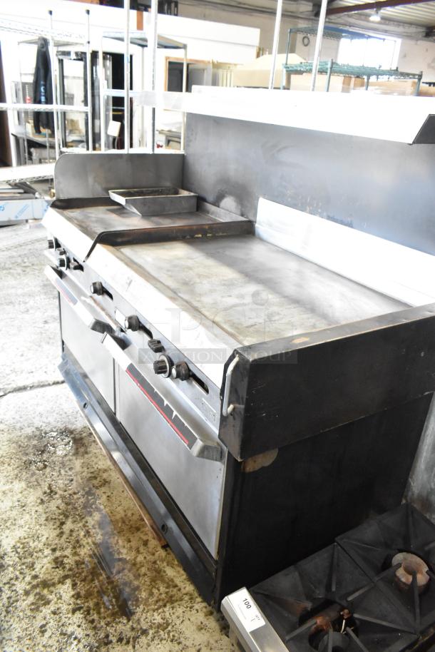 Garland stainless steel commercial gas griddle with two sections, two ovens, over shelf, and backsplash. Used condition.