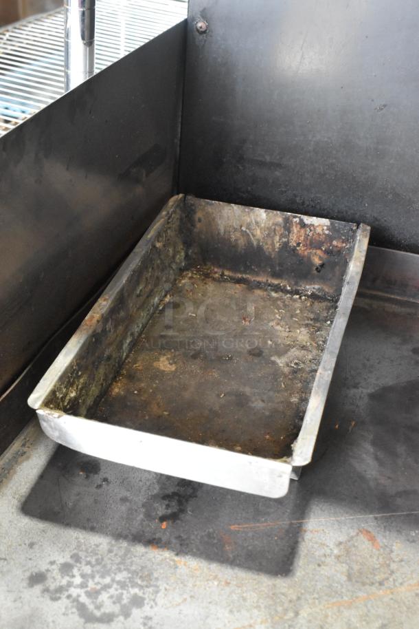 Garland stainless steel gas griddle with two sections, dual ovens, over shelf, and backsplash. Visible signs of use.