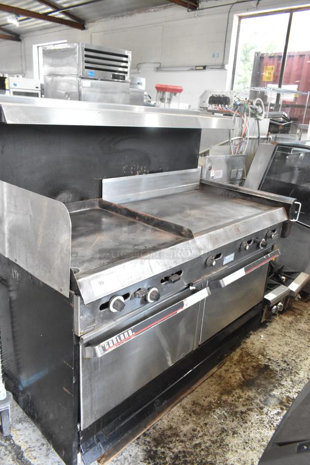 Garland stainless steel commercial gas griddle with two ovens, over shelf, and backsplash; shows general wear.