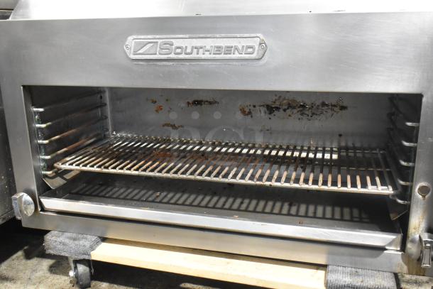 Southbend stainless steel commercial cheese melter with visible wear, open front, and rack. Brand nameplate intact.