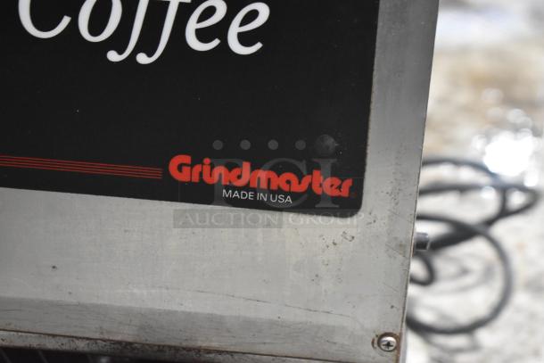 Grindmaster 115 stainless steel countertop coffee bean grinder, 115 volts, 1 phase, label "Made in USA," minor wear.