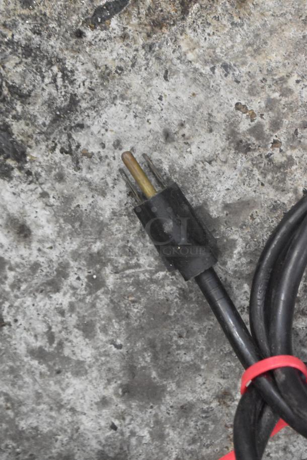 Stainless steel commercial coffee grinder power cord, model 115, 115 volts, visible plug end on textured surface.