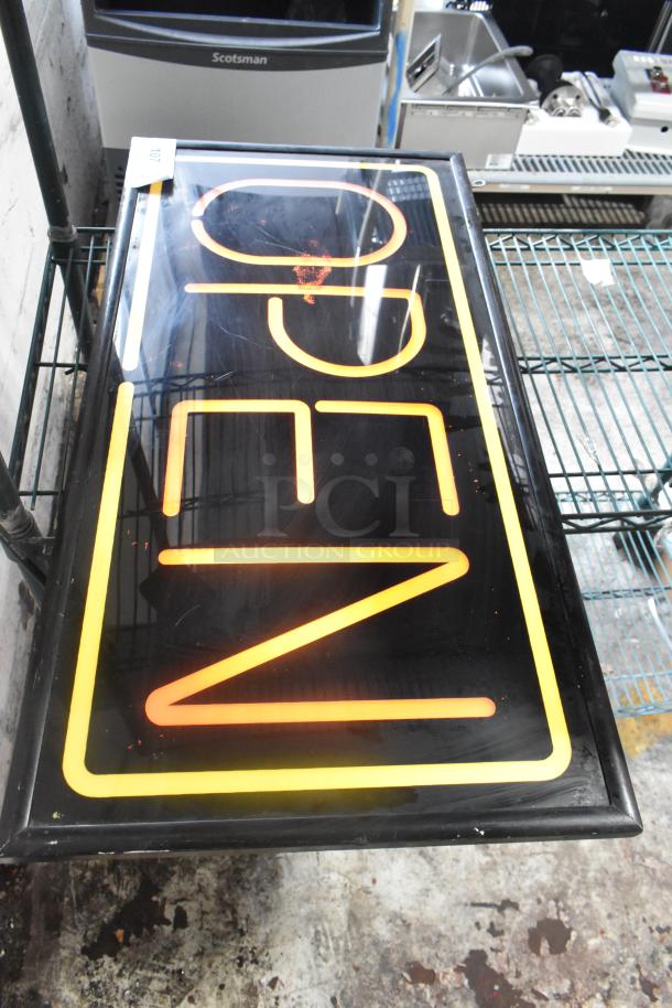 Illuminated open sign, black frame, orange text, 115 volts, single-phase. Good condition with minor wear.