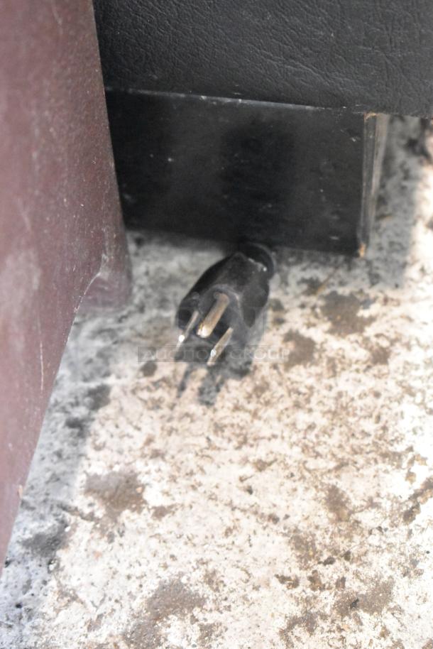 2017 True TBB-4G-LD commercial back bar cooler plug. 115 volts, 1 phase. Image shows plug condition on rough floor surface.