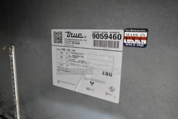 2017 True TBB-4G-LD metal commercial 3-door back bar cooler, 115 volts, label indicating make, model, and specs.