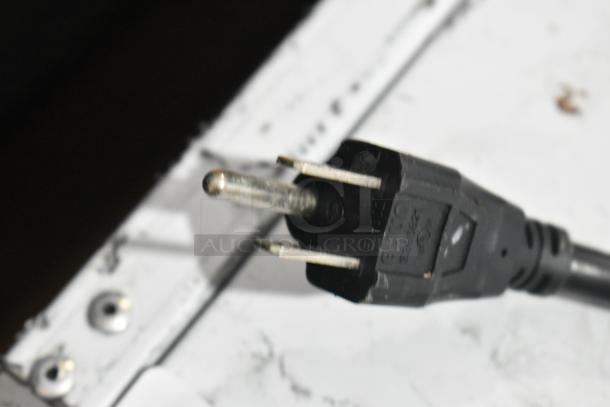 Close-up of a black power plug for the Osion OCM-350 cooler, showing prongs and part of the cord.