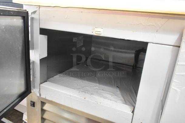 2018 Leader LM48 S/C stainless steel prep table with open storage; visible signs of wear; commercial casters included.