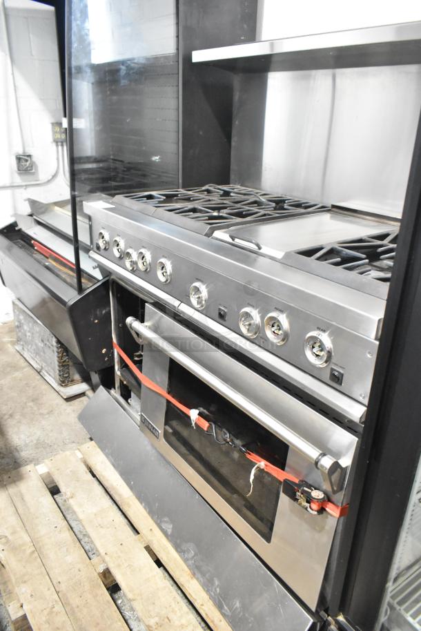 Jenn-Air stainless steel commercial 6 burner range with oven, over shelf, and backsplash. Includes control knobs and brand label.