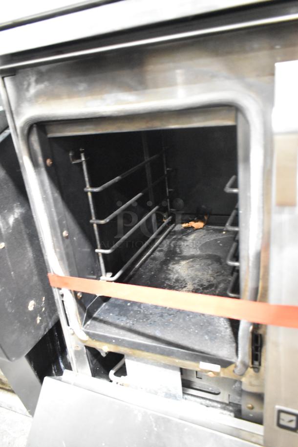 Jenn-Air stainless steel 6 burner commercial range oven interior, shows signs of use, features overshelf and backsplash.