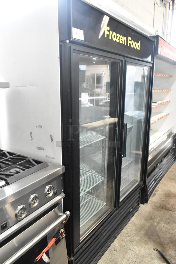 True GDM-49F commercial freezer, 2 glass doors, poly-coated racks, 115/208-230V, 1 phase, "Frozen Food" sign, good condition.