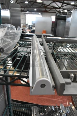 LED light strip with protective casing. Mounted on a metal rack in an industrial setting. Condition appears new.