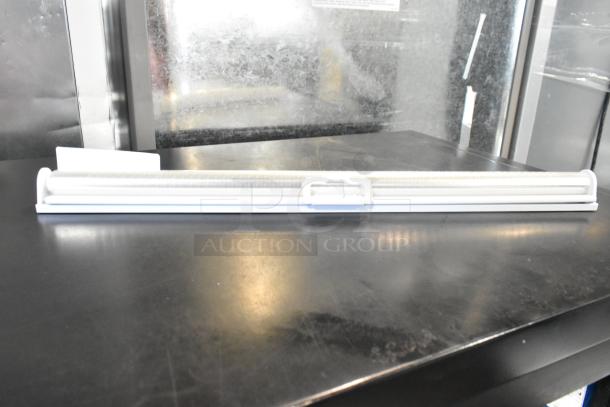 White light strip in excellent condition, mounted on a black surface, featuring a sleek design with protective cover.