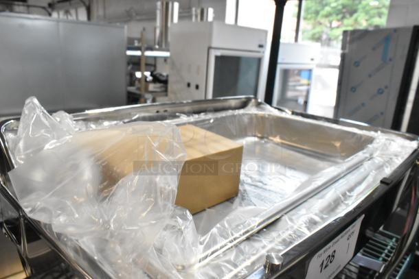 Brand new stainless steel chafing dish with minor scratches, plastic-wrapped. Large serving pan, ideal for catering.