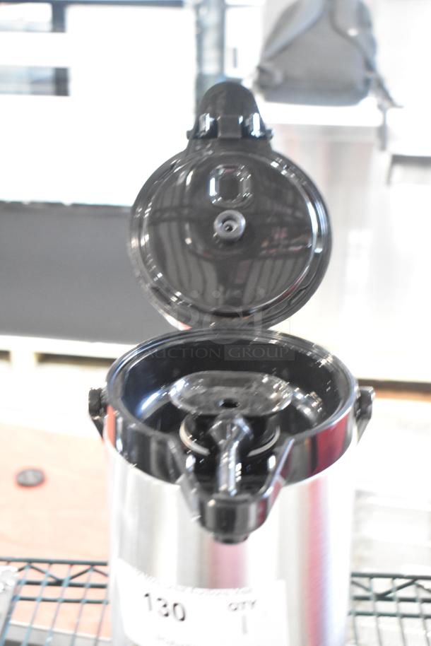 Brand new Curtis stainless steel air pot with minor scratches, open lid, black plastic top, visible label with model details.