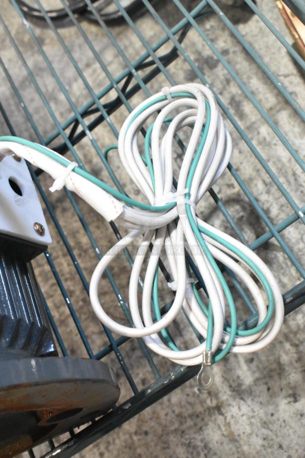 Brand new Y100L2-6 motor, scratch and dent condition, with coiled wiring and metal base, includes mounting hardware.